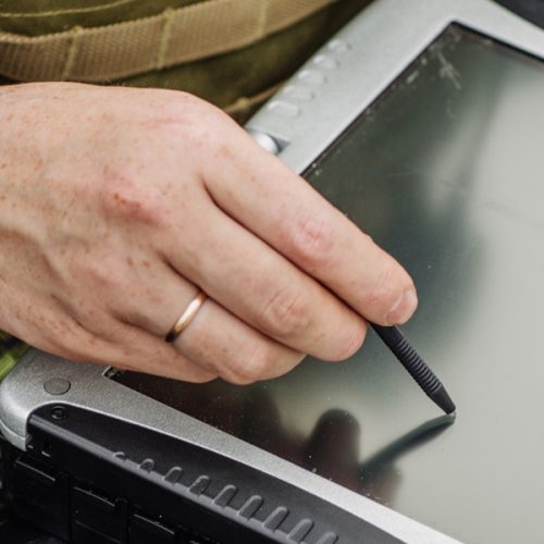 Military person writing on a ipad